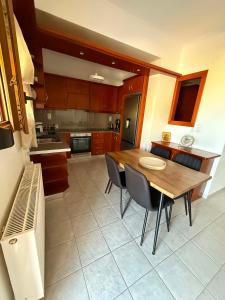 a kitchen with a wooden table and chairs in it at Mirina View Apartment #2 in Myrina