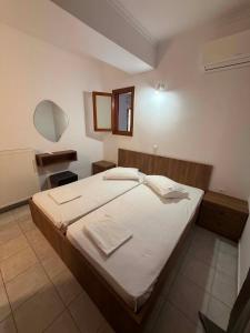 a bedroom with a large bed with white sheets at Mirina View Apartment #2 in Myrina