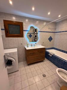 a bathroom with a sink and a washing machine at Mirina View Apartment #2 in Myrina