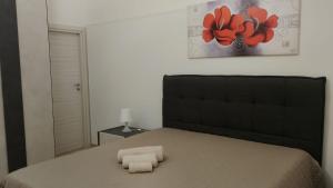 a bedroom with a bed with two towels on it at D&M House Salento in Nardò
