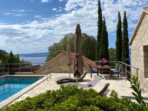 a villa with a swimming pool and a patio at Villa Nidus Onei in Omiš