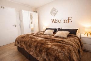 a bedroom with a large bed with a brown blanket at Wellness Ferienhaus Garden in Michendorf