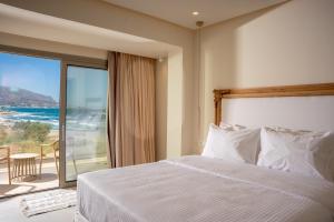 a bedroom with a bed and a view of the ocean at Akanthus Pirgos Bay in Malia