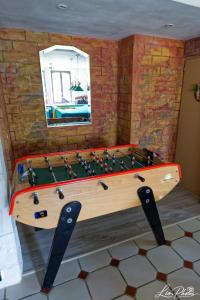 a wooden pool table in a room with a mirror at La longère in Saint-Hilaire-en-Woëvre