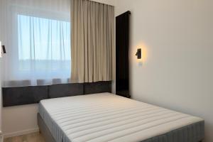 a bed in a room with a large window at Apartament Stara Fabryka 32 in Włocławek