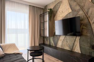 a living room with a couch and a tv on a wall at Apartament Stara Fabryka 32 in Włocławek
