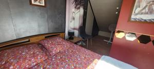 a small bedroom with a bed with colorful sheets at Guim appart in Guimiliau +1 photo