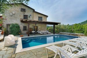 a swimming pool in front of a stone house at Villa Daphne Pool And Jacuzzi in Vescina