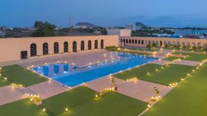 an overhead view of a building with a large pool with lights at The Democracy Hotel & Resorts Convention Center in Nashik