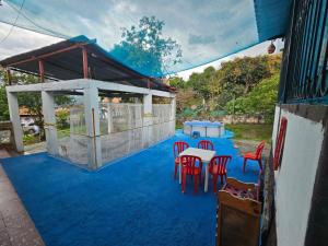 a patio with a table and chairs on a blue floor at VILLA ELSA in El Colegio