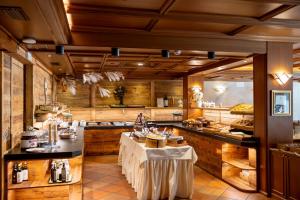 a large kitchen with wooden walls and a table with white tables at Hotel Splendid in Madonna di Campiglio