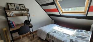 a small bedroom with a bed and a window at Guim appart in Guimiliau