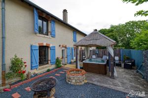 a backyard with a hot tub and a house at La longère in Saint-Hilaire-en-Woëvre