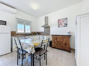 a kitchen with a table and chairs in a kitchen at Studio avec terrasse en rez de chaussée in Lapalme