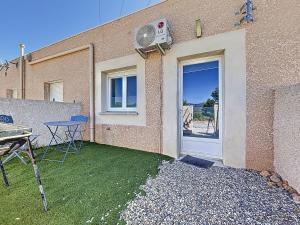 a patio with a table and a door to a building at Studio avec terrasse en rez de chaussée in Lapalme