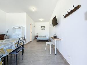 a room with a table and chairs and a dining room at Studio avec terrasse en rez de chaussée in Lapalme