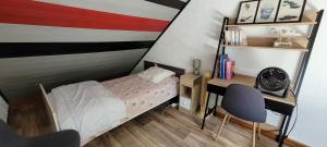 a small bedroom with a bed and a desk at Guim appart in Guimiliau