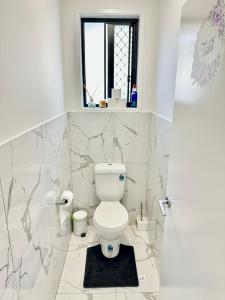 a bathroom with a toilet and a window at Noble place in Loganlea in Loganlea