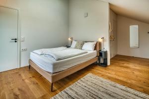a bedroom with a bed with white sheets and a rug at BlackForestChillOut - Pool - Garten - BBQ - Sauna in Stühlingen