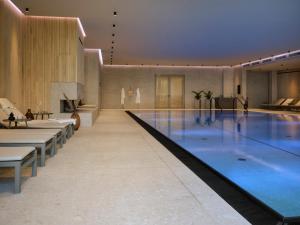 a large swimming pool in a building with tables and chairs at THE SHORELINE Sellin in Ostseebad Sellin
