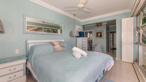 a bedroom with a bed and a ceiling fan at 62 Camarque Umdloti Beachfront in Umdloti