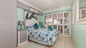 a bedroom with a bed and a window at 62 Camarque Umdloti Beachfront in Umdloti +40 photos