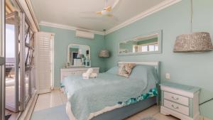 a bedroom with a bed with two stuffed animals on it at 62 Camarque Umdloti Beachfront in Umdloti