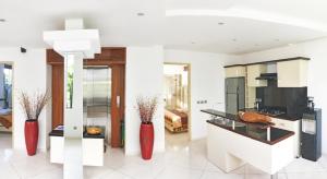 a kitchen with two red vases in a room at Flora Apartment Bali in Seminyak