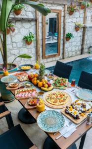 a table with plates of food on it next to a pool at The Alaçatı Ariel Hotel in Çeşme