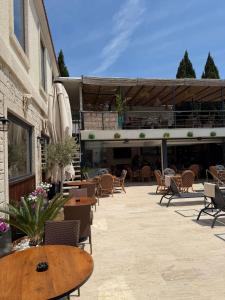a patio with tables and chairs and a building at The Alaçatı Ariel Hotel in Çeşme