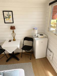 a room with a table and a chair and a small refrigerator at Rudbøl Naturcamping in Højer