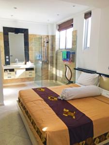 a bedroom with a large bed and a shower at Flora Apartment Bali in Seminyak
