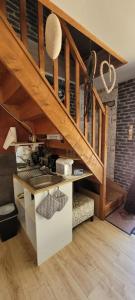 a kitchen under a wooden stairs with a counter at Guim appart in Guimiliau
