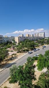 a city street with cars parked on the side of a road at Sunset Apartment Aktau Квартира в центре у моря in Aktau