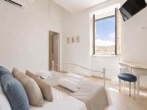a white living room with a couch and a piano at Wanderlust Experience Loggiato del duca in Bitonto