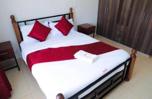 a bedroom with a large bed with red pillows at 3 Bedrooms in Eldoret in Eldoret