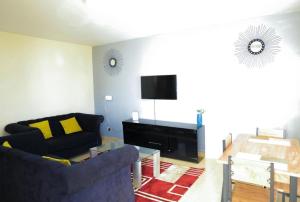 a living room with a couch and a tv at 3 Bedrooms in Eldoret in Eldoret