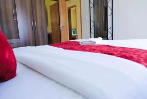 a close up of a bed with a red blanket on it at 3 Bedrooms in Eldoret in Eldoret +1 photo