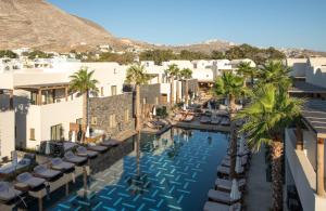 an aerial view of a hotel with a pool and palm trees at Radisson Blu Zaffron Resort, Santorini in Kamari