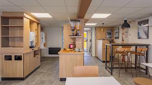 a kitchen with wooden cabinets and a bar in a room at Premiere Classe Bayonne in Bayonne