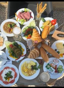a table with many plates of food on it at Phoenix Pyramids Inn in Banī Ghālib