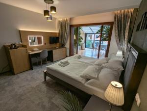 a bedroom with a large bed and a desk with a computer at Hotel Antoň in Telč