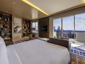 a bedroom with a large bed and a large window at Swissotel The Stamford Singapore in Singapore