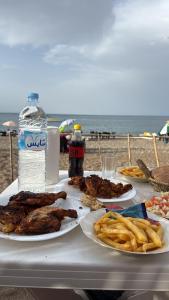 a table with plates of food and a bottle of water at Chalets MB in Tarîfa
