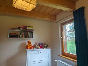 a childs room with a dresser and a window at Kocurzonka Apartamenty in Jaworzynka