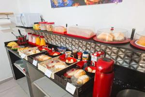 a buffet line with various foods and drinks at Pousada Casa da Fernanda, Suíte Sun in Praia Grande +16 photos
