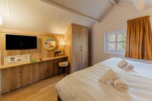 a bedroom with a large white bed with a television at Center Parcs Les Ardennes in Vielsalm +201 photos