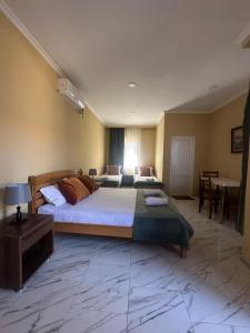 a large bedroom with two beds and a table at Cottage Shara - შარა in Ureki