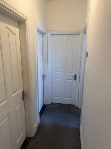 an empty hallway with two white doors in a room at 86 Watling in Gillingham