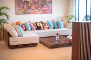 a living room with a couch with colorful pillows at One Ocean Hotel Apartments by Nest & Nomad in Msambweni +95 photos